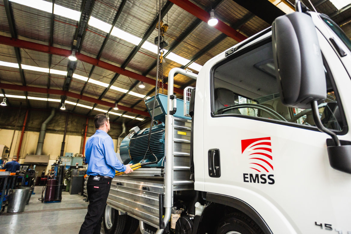 Electric motor being hoisted onto the tray of an EMSS delivery truck